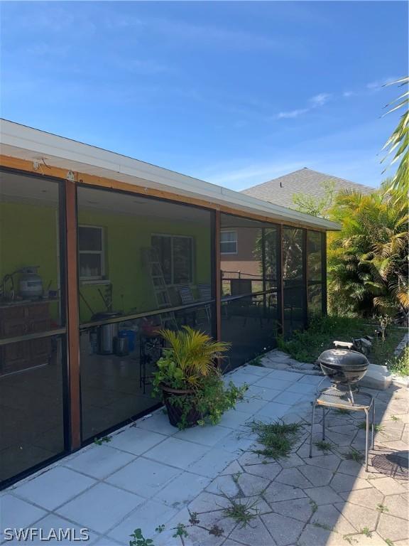 back of property with a patio and a sunroom