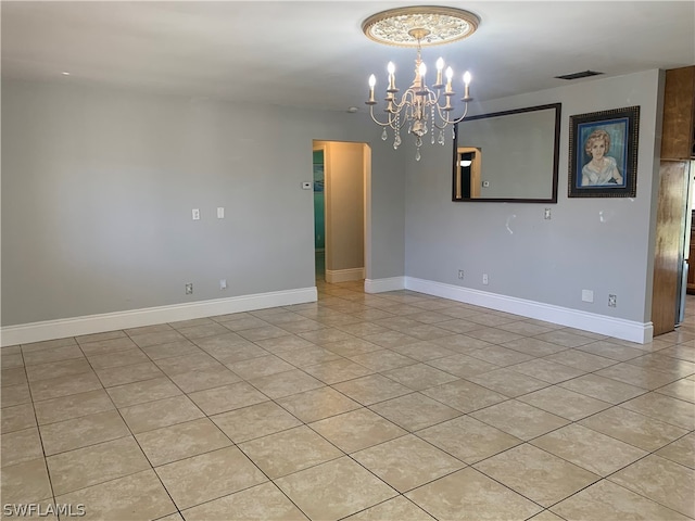 unfurnished room featuring a chandelier and light tile flooring