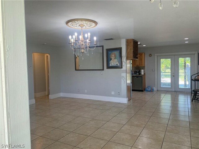 empty room with french doors, a chandelier, and light tile floors