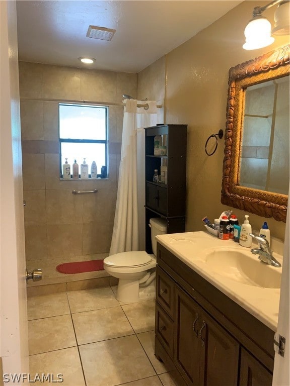 bathroom with tile flooring, toilet, and vanity