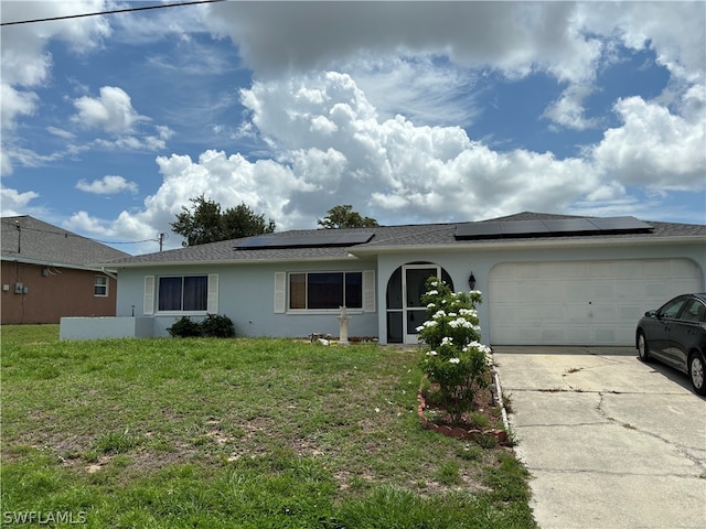 ranch-style home featuring a garage, solar panels, and a front lawn