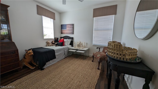 bedroom with dark hardwood / wood-style flooring and ceiling fan