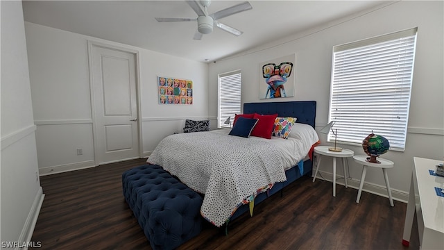 bedroom with ceiling fan, multiple windows, and dark wood-type flooring