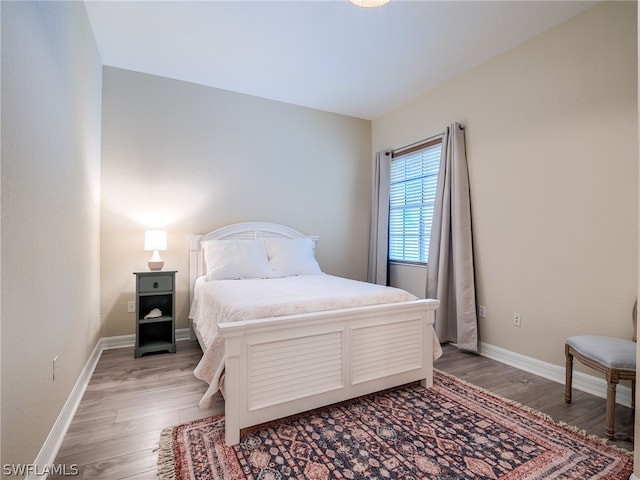 bedroom featuring light wood-type flooring and baseboards