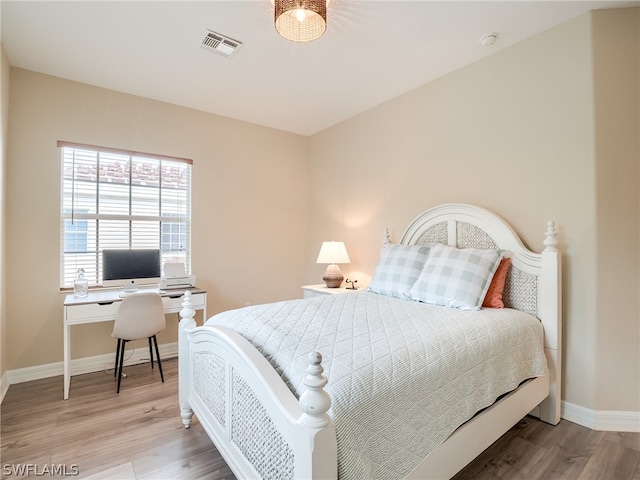 bedroom featuring light wood-type flooring, visible vents, and baseboards