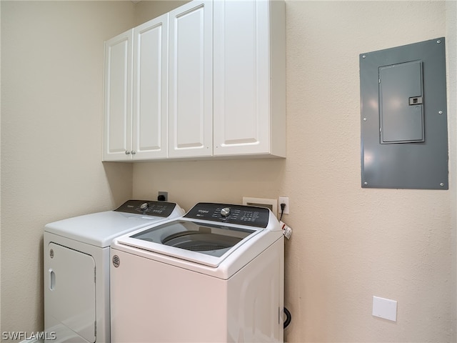 washroom with cabinets, washer and clothes dryer, and electric panel