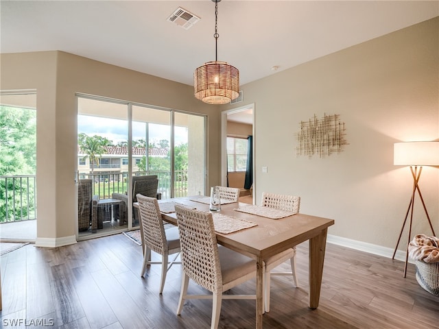 dining room featuring baseboards, visible vents, and wood finished floors