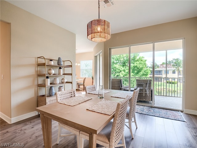 dining room with baseboards, visible vents, and wood finished floors