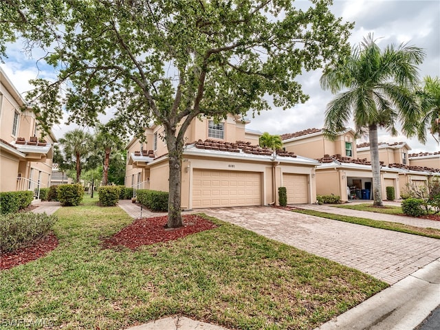 mediterranean / spanish-style house with a garage and a front lawn