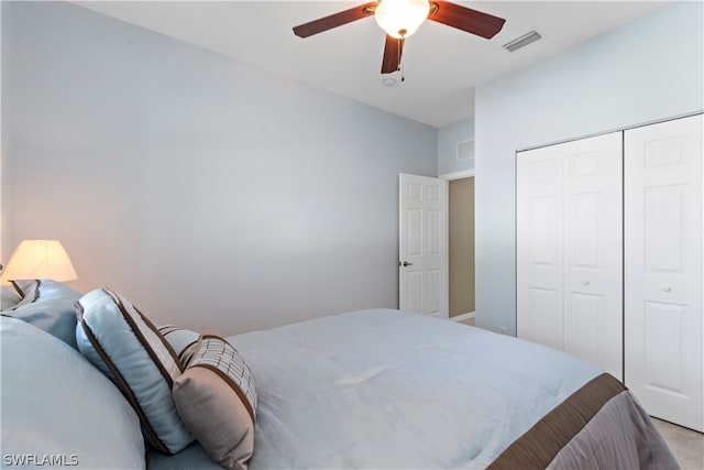 bedroom featuring light carpet, ceiling fan, and a closet