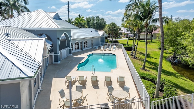 view of pool with a patio and a lawn