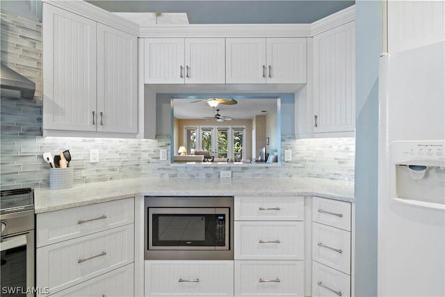 kitchen with white cabinets, tasteful backsplash, and stainless steel appliances