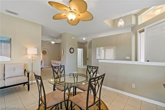 dining space with ceiling fan and light tile flooring