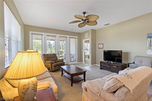 tiled living room featuring french doors and ceiling fan