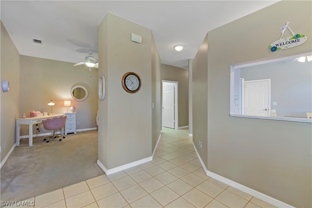 hallway featuring light colored carpet