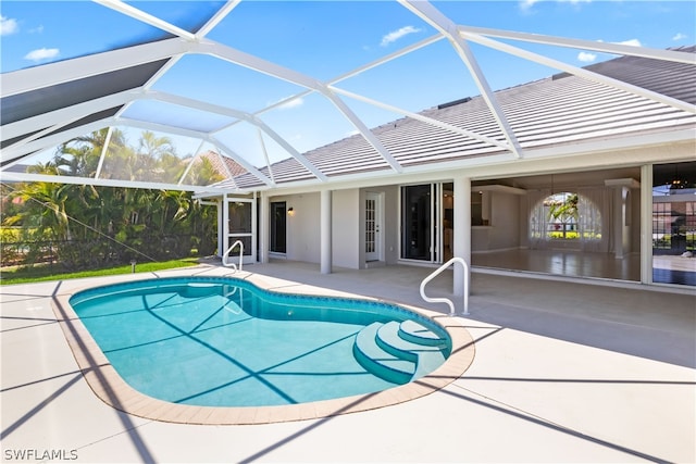 view of pool featuring glass enclosure and a patio