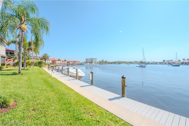 dock area with a lawn and a water view