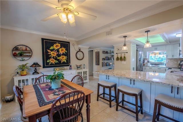 dining space with ornamental molding, ceiling fan, and light tile floors