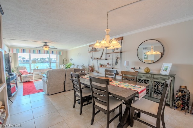 tiled dining area featuring ceiling fan with notable chandelier, a textured ceiling, and ornamental molding