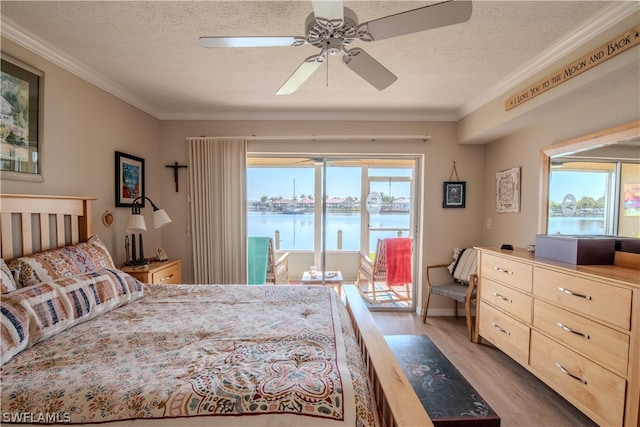 bedroom featuring a water view, ceiling fan, a textured ceiling, and light wood-type flooring