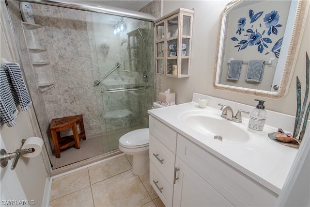 bathroom with a shower with shower door, toilet, tile floors, and large vanity