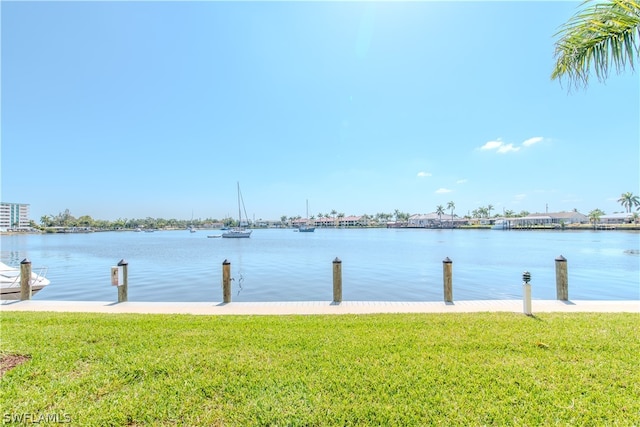 view of dock featuring a water view and a yard