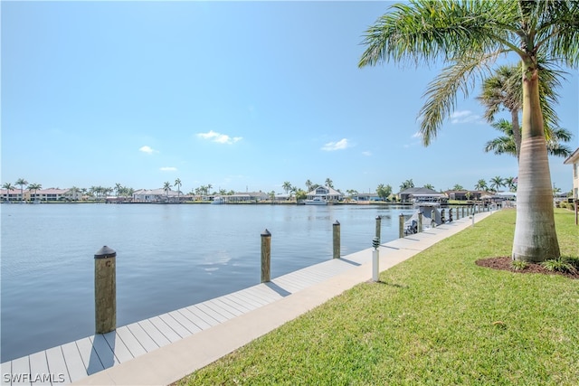 view of dock with a yard and a water view