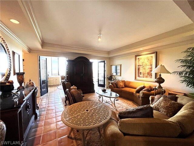 tiled living room with ornamental molding and a tray ceiling