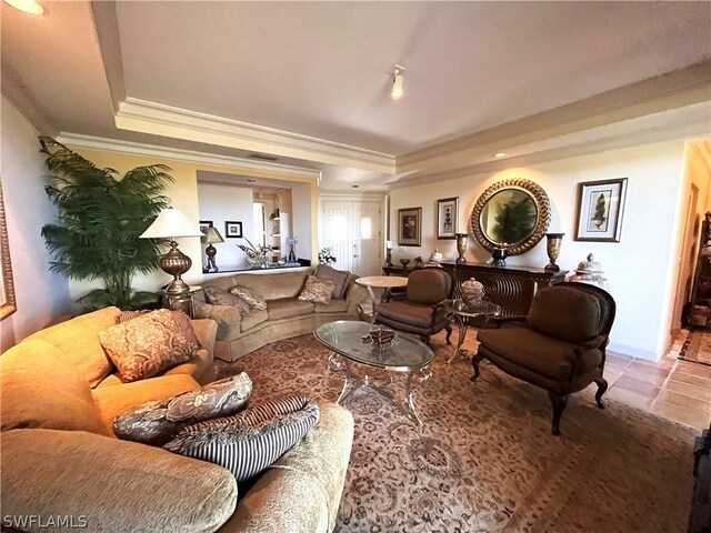 tiled living room featuring a tray ceiling and ornamental molding