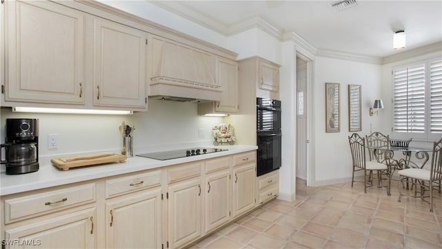 kitchen with light tile patterned floors, crown molding, premium range hood, cream cabinets, and black appliances