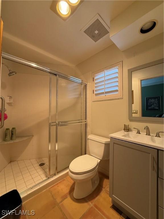 bathroom with a shower with door, vanity, and toilet