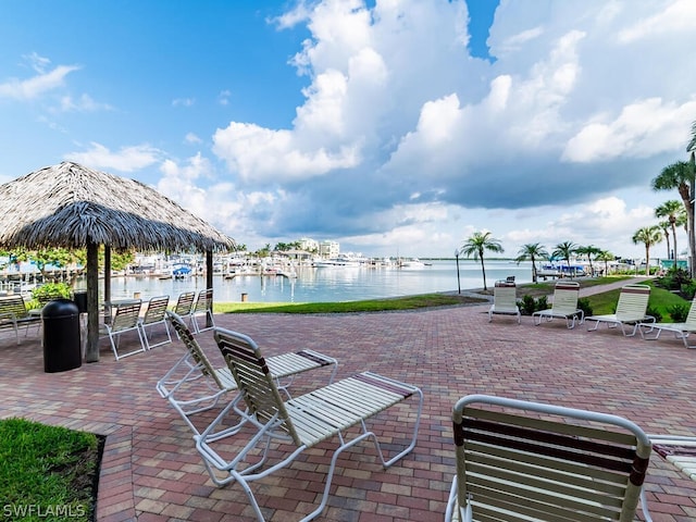 view of patio with a water view and a dock