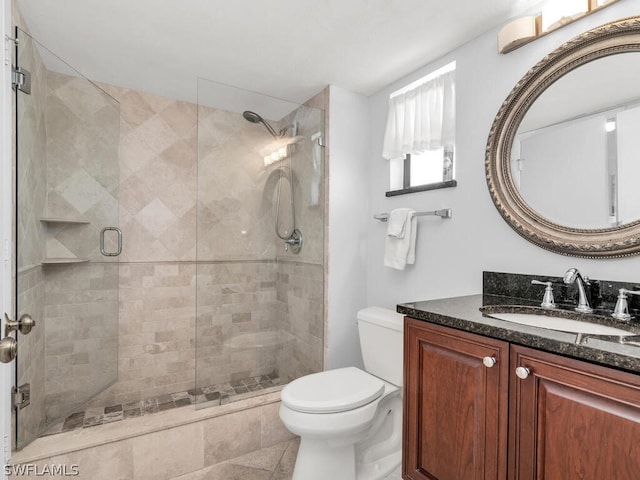 bathroom with an enclosed shower, toilet, tile floors, and vanity