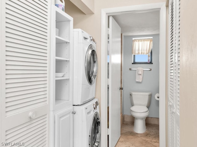 laundry room with stacked washer and dryer and light tile floors