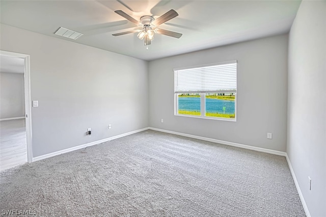 carpeted spare room with ceiling fan