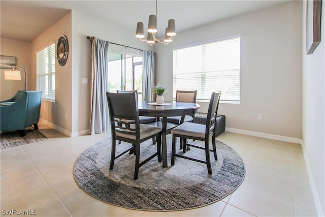 dining area featuring light tile patterned floors, a chandelier, and baseboards