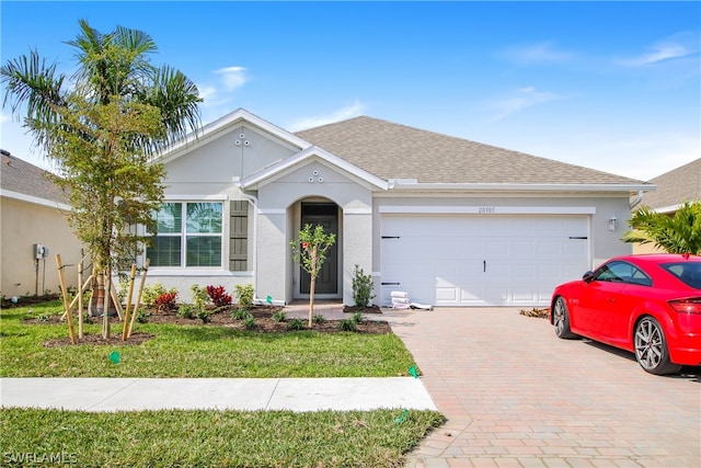 single story home featuring a garage and a front lawn