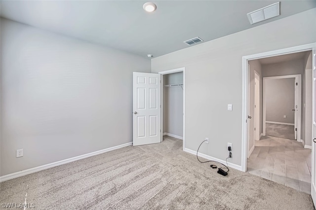 unfurnished bedroom featuring light colored carpet and a closet