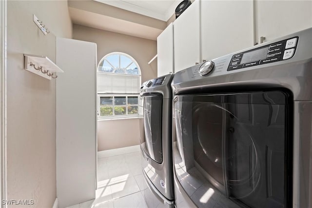 laundry area with separate washer and dryer, light tile patterned floors, cabinets, and ornamental molding