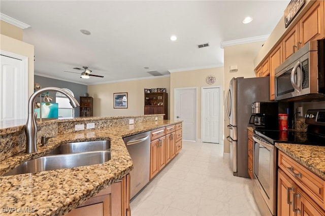 kitchen with ceiling fan, sink, light stone countertops, and appliances with stainless steel finishes