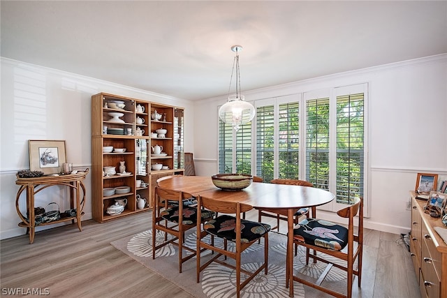 dining area featuring light hardwood / wood-style floors and crown molding