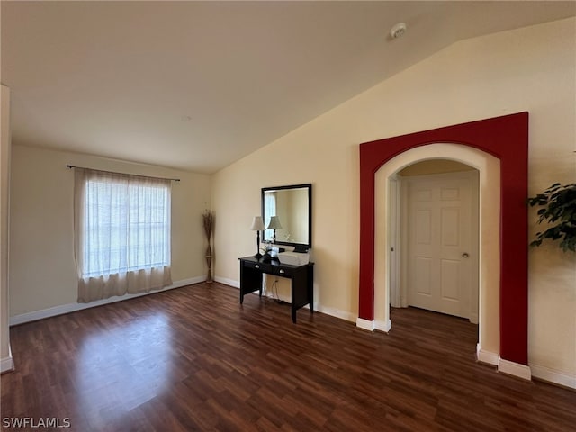 empty room featuring dark hardwood / wood-style flooring and vaulted ceiling