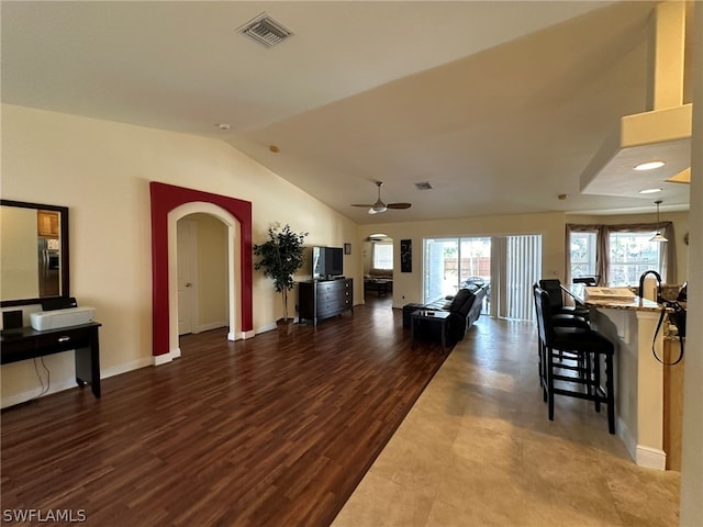 interior space with ceiling fan, dark hardwood / wood-style flooring, and vaulted ceiling