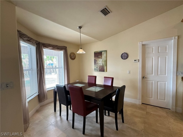 dining area with light tile floors and lofted ceiling