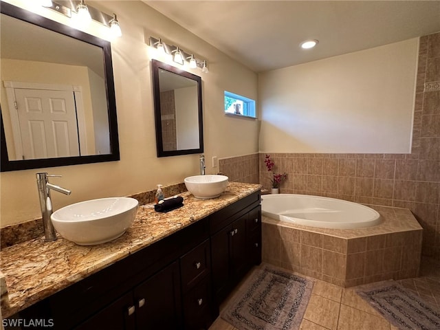 bathroom featuring tile floors, dual vanity, and tiled tub