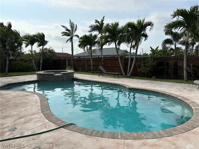 view of swimming pool featuring a patio area and an in ground hot tub