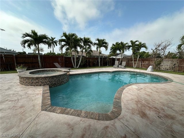 view of swimming pool featuring a patio area and an in ground hot tub