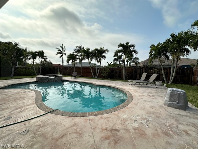 view of swimming pool featuring a patio area and an in ground hot tub