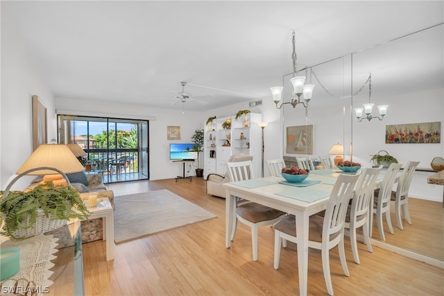 dining room with hardwood / wood-style floors and ceiling fan with notable chandelier