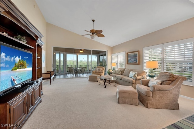 living area with light carpet, a wealth of natural light, high vaulted ceiling, and a ceiling fan